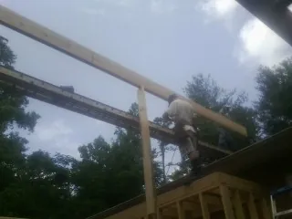 Carpenter setting a ridge beam over a new addition frame — Ice Dam Removal by Roofing Brothers in South Plymouth
