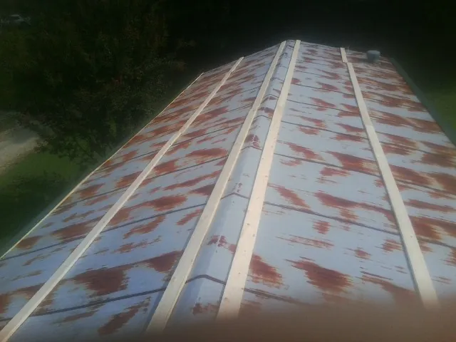 Rusted metal roof panels with new wood purlins before replacement — Storm Damage Roof Repair in South Plymouth by Roofing Brothers