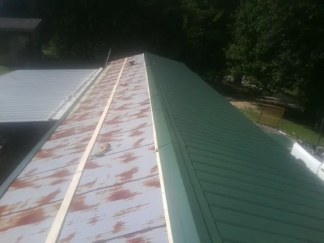 Old rusted panels beside newly installed green metal roofing — Wind Damage Roof Repair by Roofing Brothers in South Plymouth