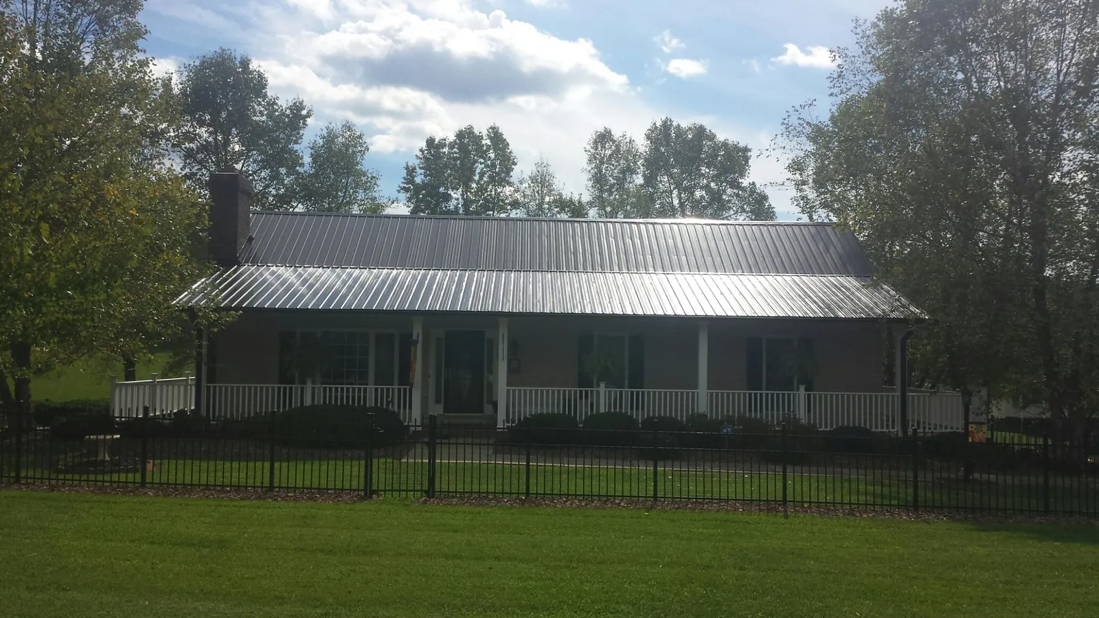 Gray metal roof on a brick ranch with a full width front porch — Gutter Guard Installation work by our crew in South Plymouth