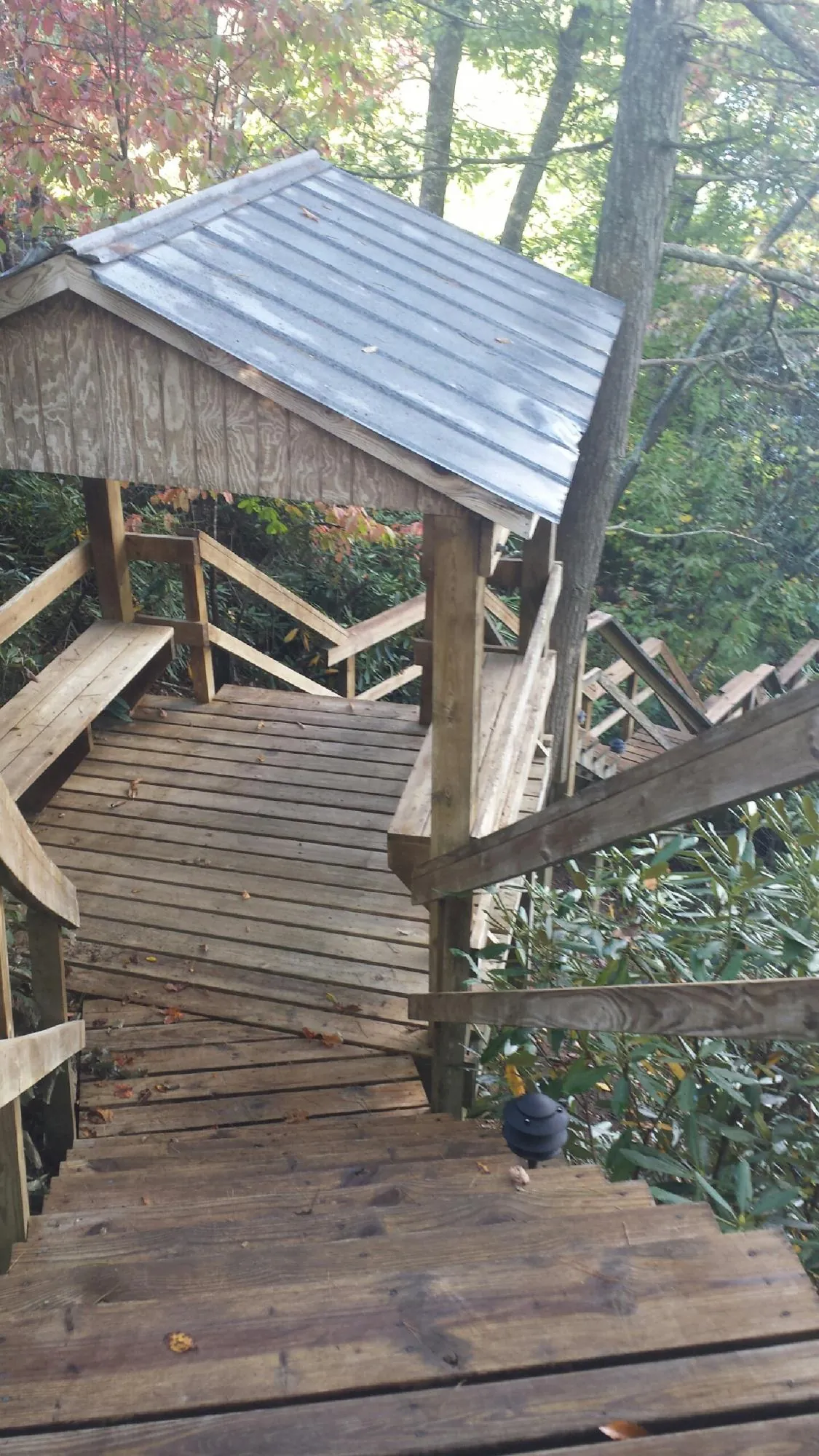 Metal roofed shelter over wooden steps on a wooded walkway — Skylight Repair & Installation work by our crew in South Plymouth