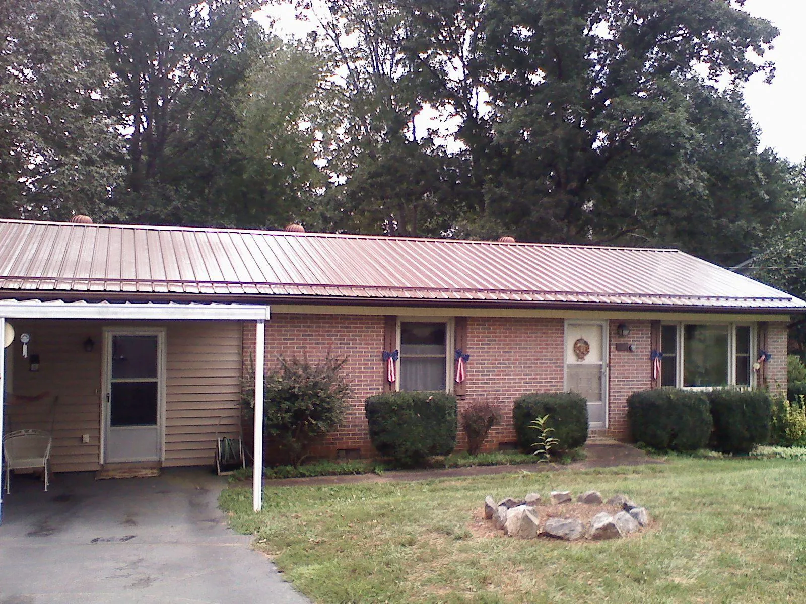 Bronze metal roof and carport on a brick ranch home — Roof Repair work by our crew in South Plymouth